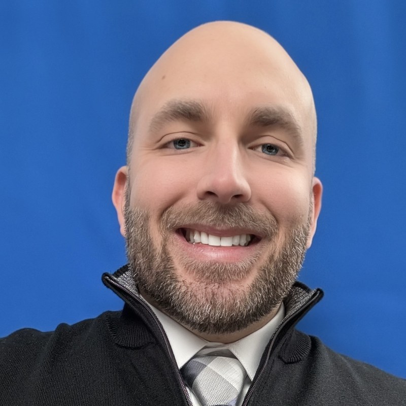 Frank Rizzo, Chicago-based actor — front-facing color headshot, blue backdrop