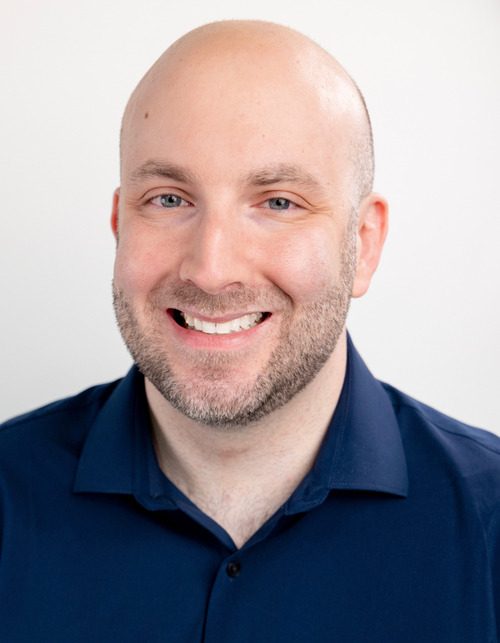 Frank Rizzo, Chicago-based actor - broad smile color headshot, navy dress shirt, white backdrop